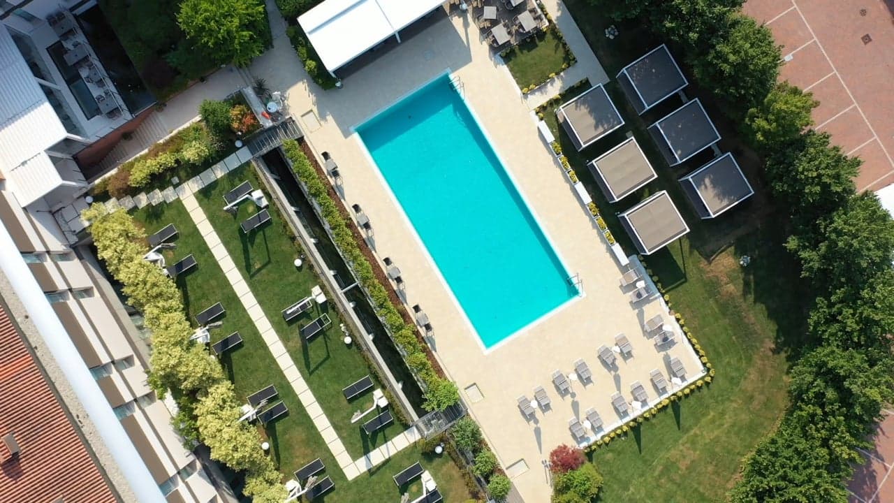 Aerial still of a pool and grounds from a Biztour film